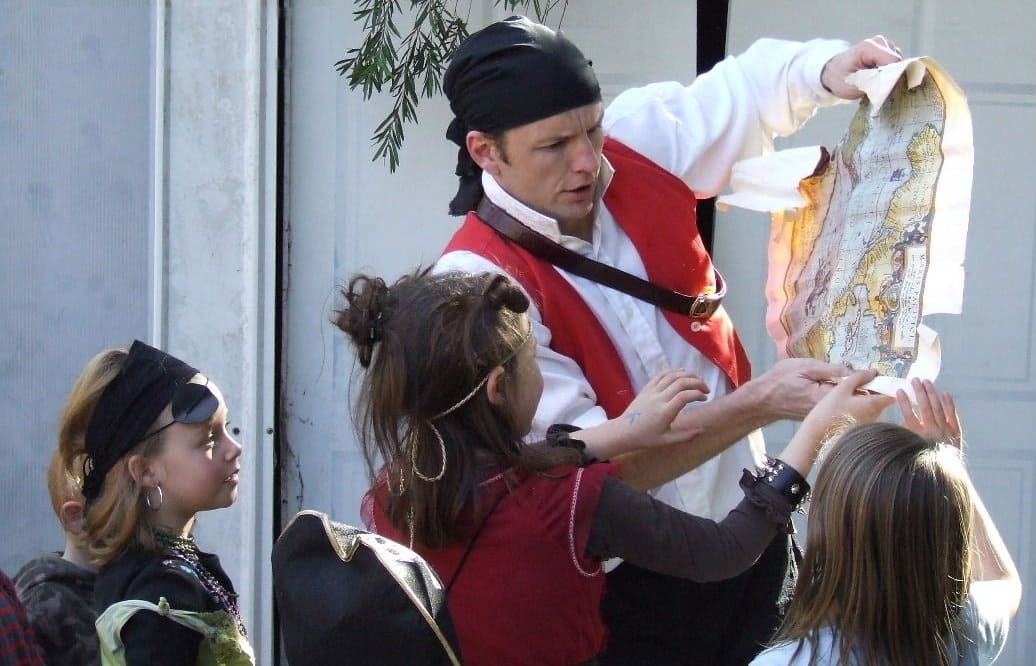 Capt'n Kenny the Irish Pirate inspects his treasure map with young buccaneers at kids parties in Sydney